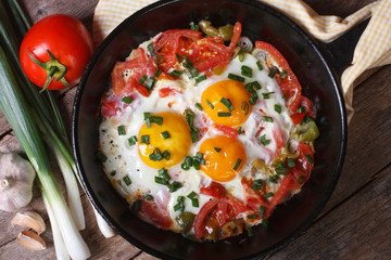 Fried eggs with vegetables on a  pan and the ingredients