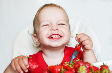 happy toddler boy eating strawberries