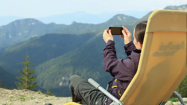 Woman uses a smartphone to video a beautiful view