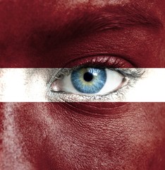 Human face painted with flag of Latvia