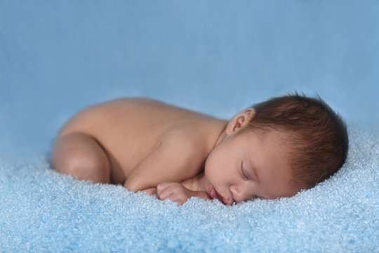 Newborn Infant Boy Sleeping on a Cute Set