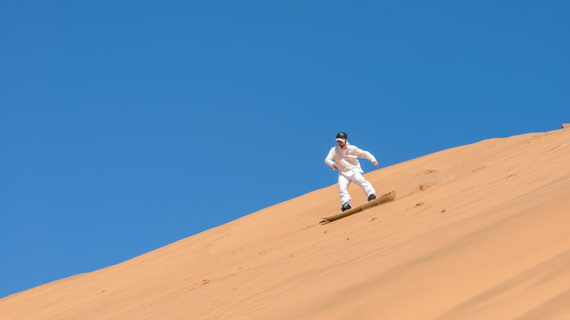 Man sandboarding in Namibia