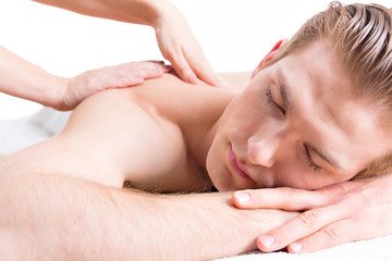 Obraz na płótnie Canvas Handsome man enjoying a deep tissue back massage.