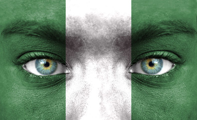 Human face painted with flag of Nigeria - obrazy, fototapety, plakaty