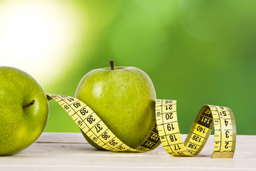 green apples with tape measure, concept of healthy diet