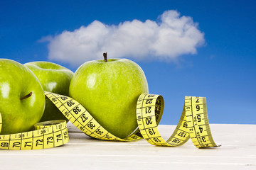 green apples with tape measure, concept of healthy diet