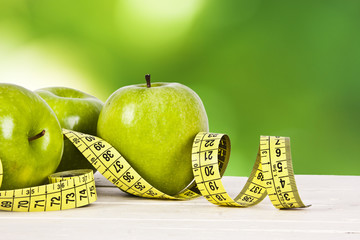 green apples with tape measure, concept of healthy diet