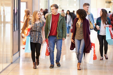 Group Of Young Friends Shopping In Mall Together