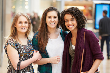 Three Female Friends Shopping In Mall Together