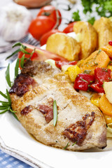 Joint of pork with baked potatoes and fresh vegetables