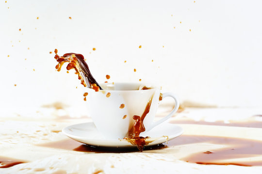 Cup of spilling coffee creating beautiful splash