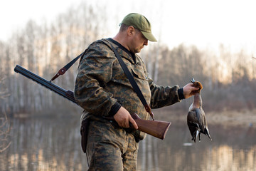 a hunter with a dead duck