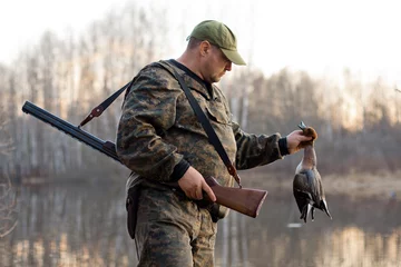 Photo sur Aluminium Chasser a hunter with a dead duck