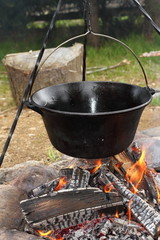 big metal pot on camp fire