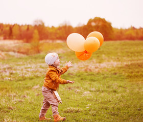 happy girl with orange balloons outdoor