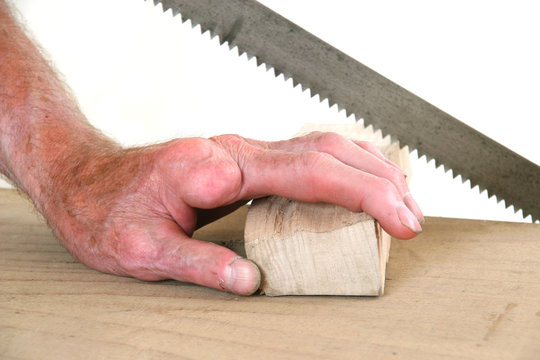 Joiner without one finger sawing a piece of wood
