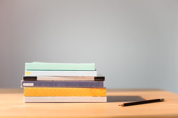 Books on the table. No labels, blank spine and pencil.