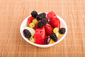 Berries Melons and Grapes in White Bowl