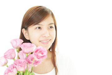 Obraz na płótnie Canvas 花を持つ笑顔の女性
