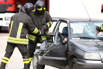 firefighters with pneumatic shears open the car doors