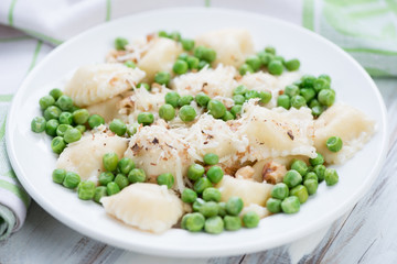 Ravioli served with green peas, walnuts and parmesan