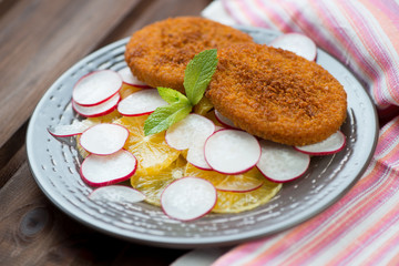 Roasted fish burgers with oranges and radish, horizontal shot