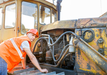 working  examining bulldozer engine © JENOCHE