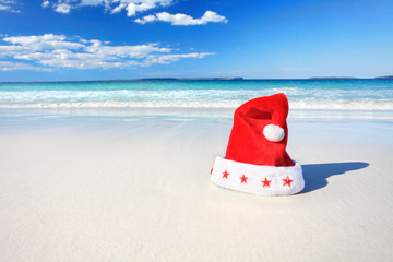 Fototapeta na wymiar Christmas Santa hat on sunny beach in Australia