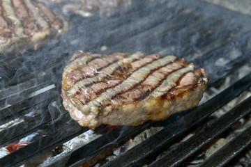 beef steak cooking on an open flame grill
