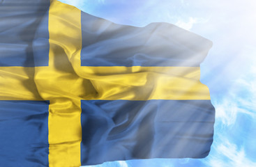Sweden waving flag against blue sky with sunrays