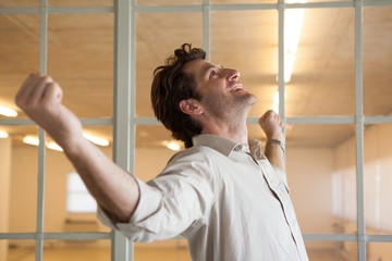 Casual smiling businessman with arms outstretched