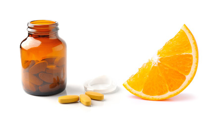 Orange fruit with vitamin c tablet and  bottle isolated on the w