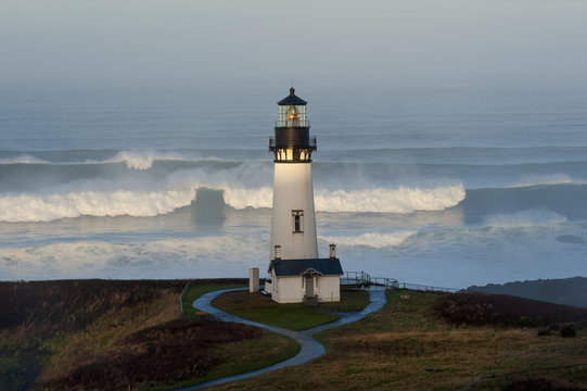 The historic Yaquina Head tower lighthouse on a headland overlooking the Pacific coastline.
