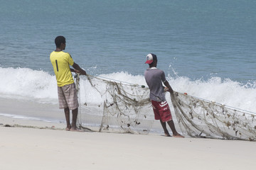 Zwei Fischer mit Netz am Strand von Beau Vallon