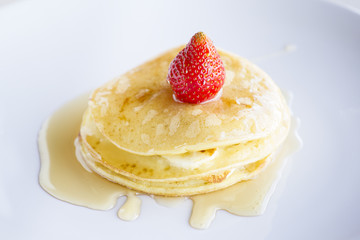 Pancakes and strawberry with maple syrup