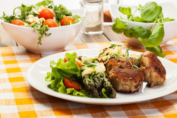 Meatballs served with boiled potatoes and asparagus