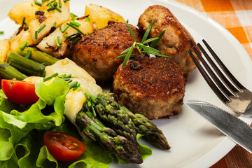 Meatballs served with boiled potatoes and asparagus