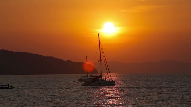 Sailing yacht illuminated by the light of the sun setting