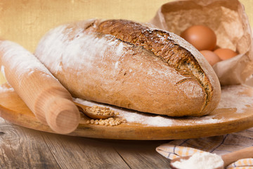 Homemade bread and ingredients, on a rural vintage wooden table.