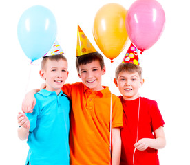 Three little boys with coloured balloons and party hat.