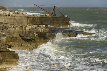 Crashing waves, rocks and a boat crane, Portland Bill