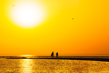 Orange sunset over the sand spit in the sea