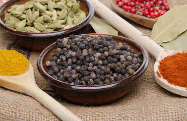 Composition of wooden spoons and cups with cardamom, pepper, pap