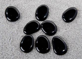 Obraz na płótnie Canvas Composition of black pebbles on the sand