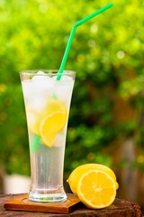Glass of fresh lemonade, on garden table.