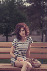 Pretty beautiful red curly hair woman at the park