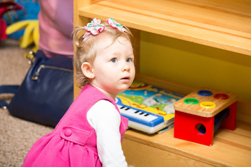 Fototapeta na wymiar Little child girl playing in kindergarten in Montessori