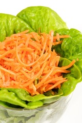 Lettuce and carrot salad in glass bowl.