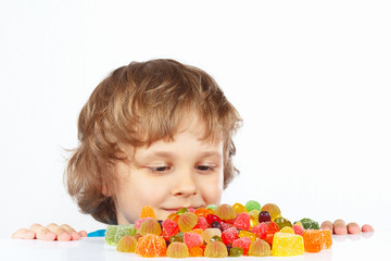 Little child with jelly candies on a white background