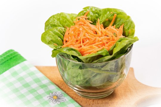Lettuce and carott salad in glass bowl.